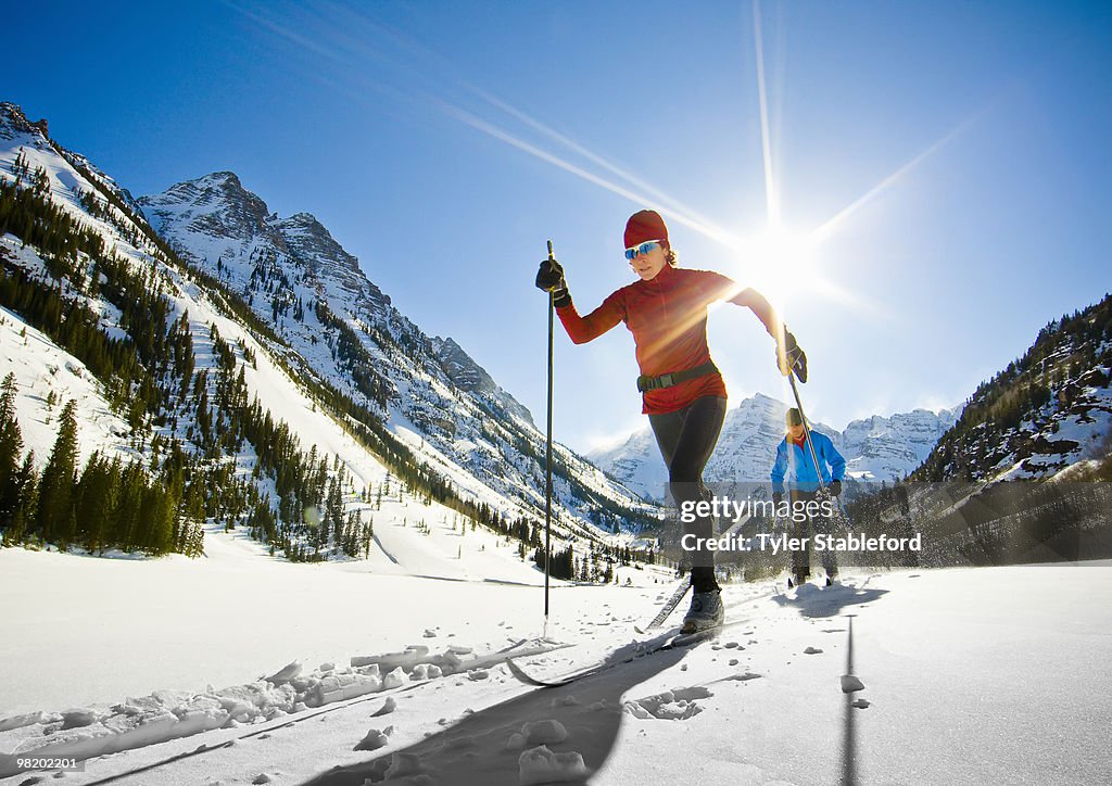 Front-view of two female nordic skiers skiing.