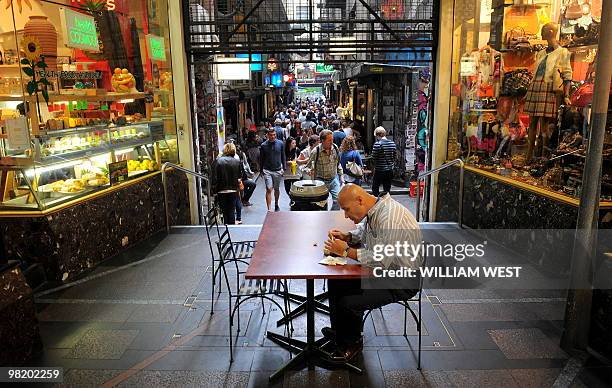 Man enjoys his lunch in one of Melbourne's inner-city laneways which is home to many vibrant bars, cafes, restaurants, boutiques, sushi bars and...