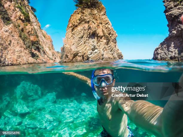 guy taking selfie doing snorkel in costa brava during summer vacations. - debat fotografías e imágenes de stock