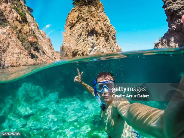 guy taking selfie doing snorkel in costa brava during summer vacations. - debat fotografías e imágenes de stock
