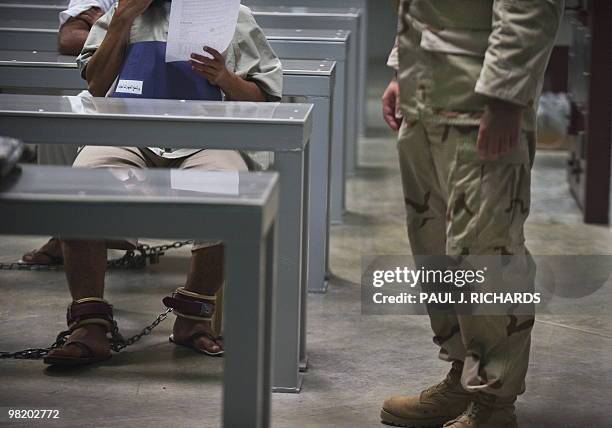 In this photo reviewed by US military officials, a guard stands nearby as detainees inside Camp VI attend a life skills class that includes resume...