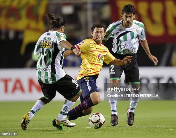 Argentina´s Victor Lopez and Walter Erviti from Banfield fights for the ball against Miguel Sabah from Mexico´s Morelia during their Copa...