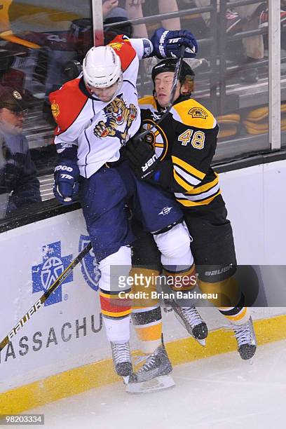 Matt Hunwick of the Boston Bruins checks Radek Dvorak of the Florida Panthers along the boards at the TD Garden on April 1, 2010 in Boston,...
