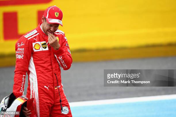 Third place qualifier Sebastian Vettel of Germany and Ferrari looks on in parc ferme during qualifying for the Formula One Grand Prix of France at...