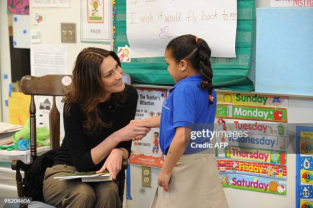 French First Lady Carla Bruni Sarkozy visits with a child at a KIPP school , a school for underprivileged pupils in Washington, DC on March 30, 2010....