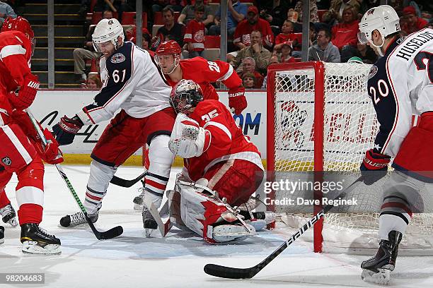 Jimmy Howard of the Detroit Red Wings defends the net as teammate Brian Rafalski and Kristian Huselius of the Columbus Blue Jackets watch for the...