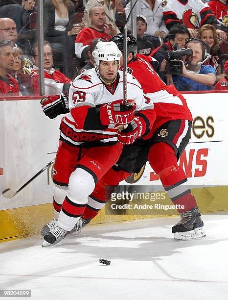 Chad LaRose of the Carolina Hurricanes skates away from Andy Sutton of the Ottawa Senators with the puck at Scotiabank Place on April 1, 2010 in...