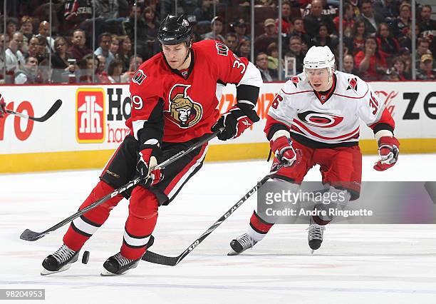 Matt Carkner of the Ottawa Senators stickhandles the puck as Jussi Jokinen of the Carolina Hurricanes gives chase at Scotiabank Place on April 1,...