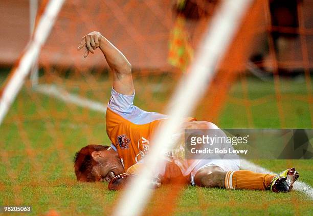 Houston Dynamo forward Brian Ching lays on the pitch in pain as he calls to the bench for assistance after taking a fall in the first half at...