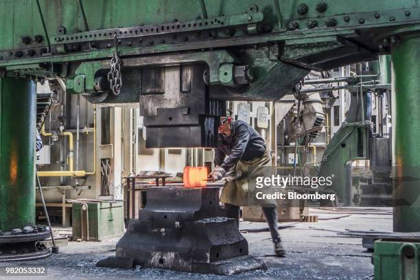 Worker positions red hot metal in a metal shaper at the Turboatom OJSC plant in Kharkiv, Ukraine, on Friday, June 22, 2018. Turboatom OJSC is a power...