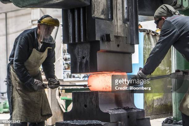Workers position red hot metal in a metal shaper at the Turboatom OJSC plant in Kharkiv, Ukraine, on Friday, June 22, 2018. Turboatom OJSC is a power...