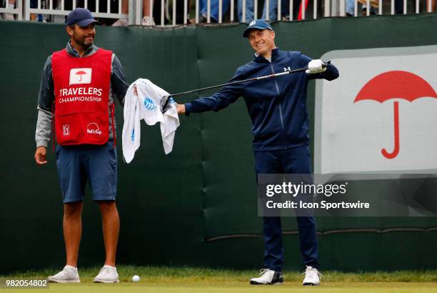 Jordan Spieth of the United States and caddie Michael Greller share a laugh on the first tee during the Third Round of the Travelers Championship on...