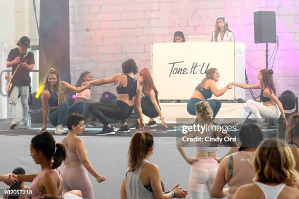 Co-founders, Tone It Up Katrina Scott and Karena Dawn lead yoga on stage at the Studio Tone It Up Live! at Duggal Greenhouse on June 23, 2018 in...