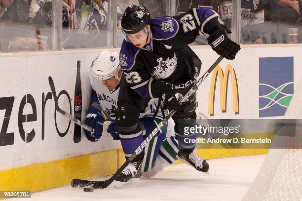 Andrew Alberts of the Vancouver Canucks is checked into the boards by Dustin Brown of the Los Angeles Kings on April 1, 2010 at Staples Center in Los...