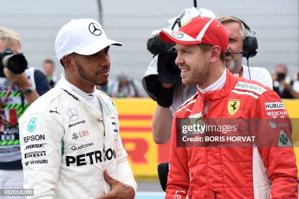 Pole position winner Mercedes' British driver Lewis Hamilton speaks with third placed Ferrari's German driver Sebastian Vettel after the qualifying...