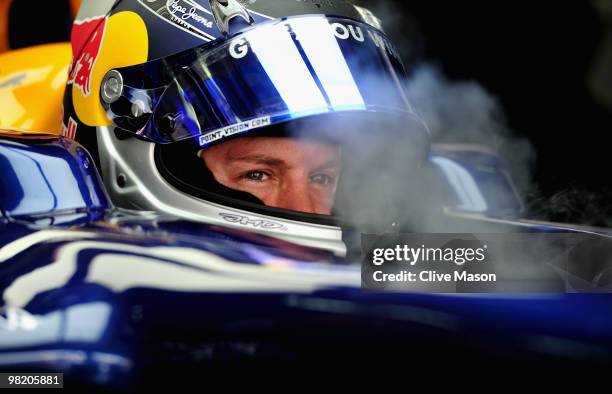 Sebastian Vettel of Germany and Red Bull Racing has dry ice blown into his car to keep cool as he prepares to drive during practice for the Malaysian...