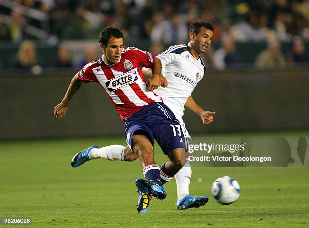 Jonathan Bornstein of Chivas USA pass the ball under pressure from Juninho of the Los Angeles Galaxy in the first half of their MLS match at the Home...