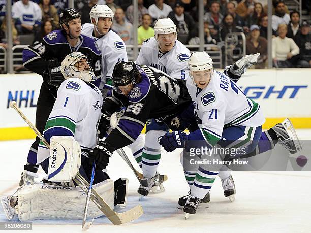 Michal Handzus of the Los Angeles Kings is knocked into Roberto Luongo of the Vancouver Canucks by Mason Raymond during the second period at the...