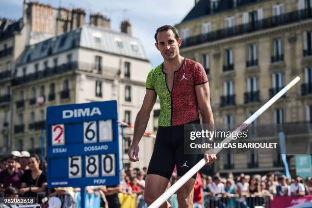 French pole vaulter Rene Lavillenie looks over as he performs in front of the public on the Pont d'Arcole in the center of Paris during the "Olympics...