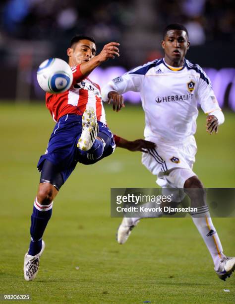 Michael Umana of Chivas USA clears the ball away from Edson Buddle of the Los Angeles Galaxy during the second half of the MLS soccer match on April...