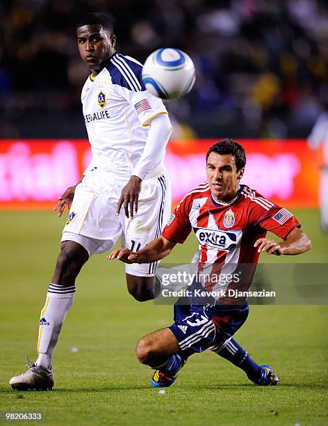 Jonathan Bornstein of Chivas USA falls as he defends against Edson Buddle of the Los Angeles Galaxy during the second half of the MLS soccer match on...
