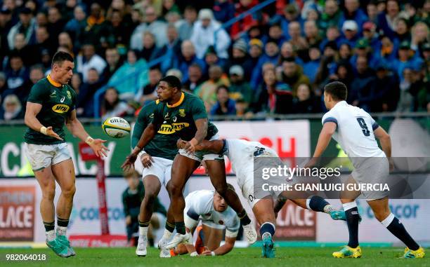 South Africa's wing Aphiwe Dyantyi passes the ball to teammate Jesse Kriel as he is tackled by England's tight head prop Kyle Sinckler during the...