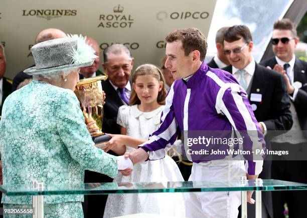 Queen Elizabeth II shakes the hand of jockey Ryan Moore after he rode Merchant Navy to victory in the Diamond Jubilee Stakes during day five of Royal...