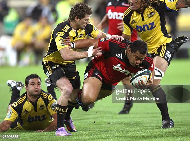 Ti'i Paulo of the Crusaders is tackled by Cory Jane and Piri Weepu of the Hurricanes during the round eight Super 14 match between the Hurricanes and...