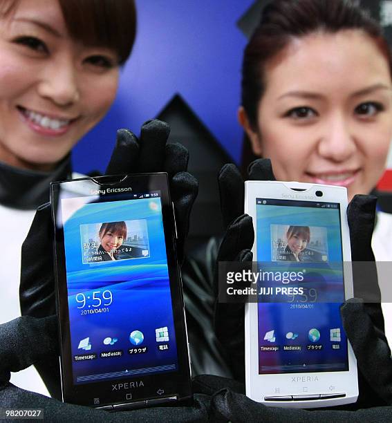 Employees of Japanese mobile communication company NTT docomo display new smartphone "Xperia", manufactured by Sony Ericsson and based on Android OS,...