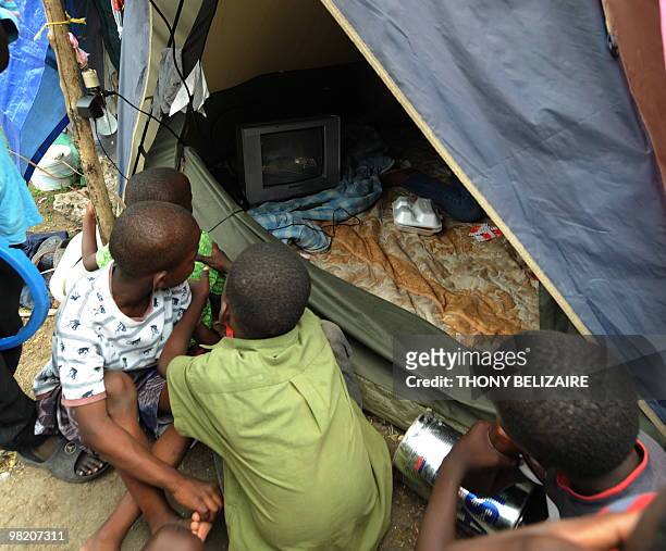 Children watch television on April 01, 2010 in a tent city of Petion-Ville, a neighborhood of Port-au-Prince. The global community has pledged nearly...