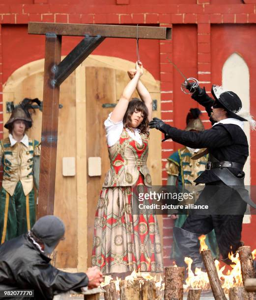 June 2018 Waren, Germany: Witch hunter Domberg forces apothecaries' daughter Laura onto the pyre during the theatre piece "Im Bann des Hexenjaegers"...