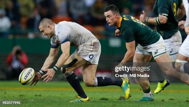 England player Mike Brown picks up the ball, while South African player Jesse Kriel watches on at Newlands Stadium on June 23, 2018 in Cape Town,...