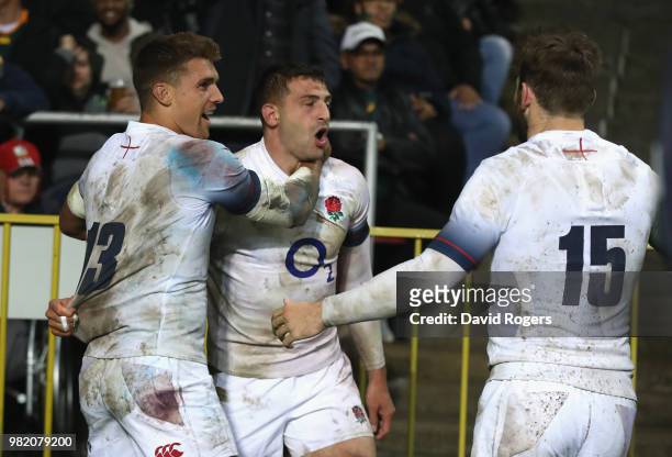 Jonny May of England celebrates with team mates Henry Slade and Elliot Daly after scoring a try during the third test match between South Africa and...