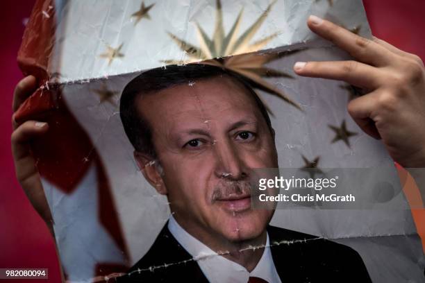 Supporter holds up a poster of Turkey's President Recep Tayyip Erdogan ahead of the start of an AK Parti election rally in Eyup on June 23, 2018 in...