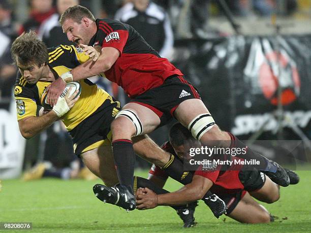 Conrad Smith of the Hurricanes is tackled by Kieran Read and Ti'i Paulo of the Crusaders during the round eight Super 14 match between the Hurricanes...