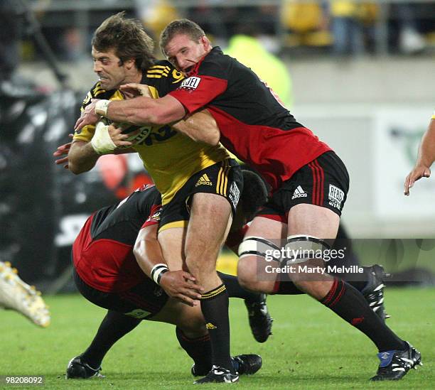 Conrad Smith of the Hurricanes is tackled by Kieran Read and Ti'i Paulo of the Crusaders during the round eight Super 14 match between the Hurricanes...