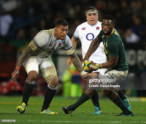 Siya Kolisi of South Africa looks to pass the ball as Nathan Hughes looks on during the third test match between South Africa and England at Newlands...