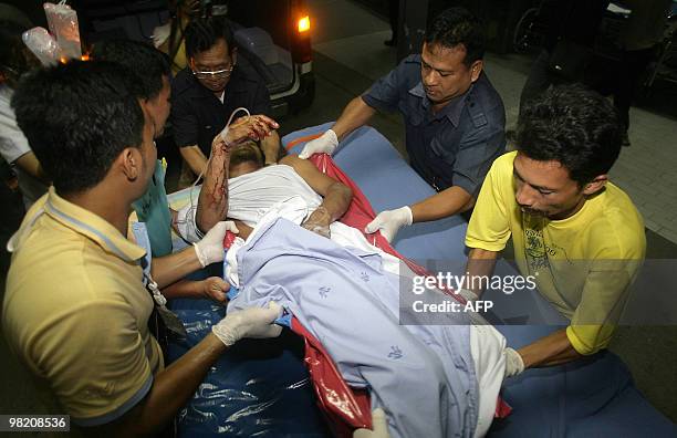 Hospital workers move an injured Thai Muslim villager from an ambulance to a hospital after a shoot out involving suspected separatist militants at a...