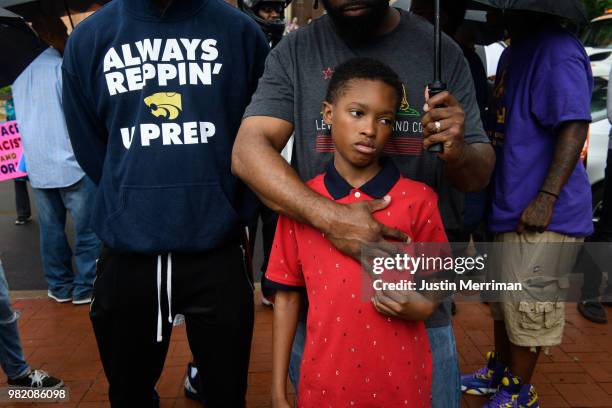 Hasaan Watts stands with his father, Harry, as they listen to speakers gathered for Pittsburgh's sixth Juneteenth celebration on June 23, 2018 in...