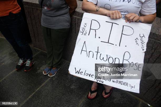 Woman holds a sign remembering Antwon Rose who was killed in a police shooting on Tuesday as she joins people gathered for Juneteenth celebrations on...