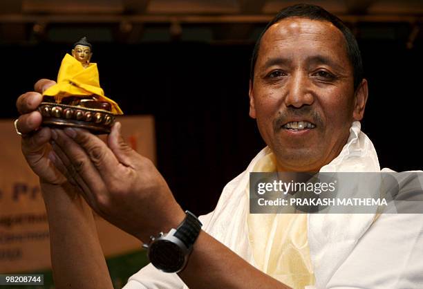 Nepalese climber Apa Sherpa, who holds the world record for most successful climbs of Mount Everest with 19 ascents, poses with a statue of Buddha...