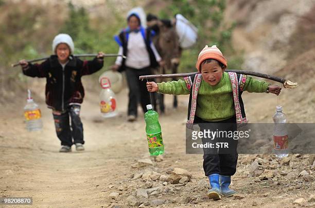 Two boys carry bottles of water during a severe drought in Kunming, southwest China's Yunnan province on March 31, 2010. China said that more than 24...