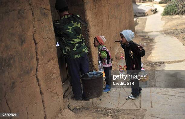 Children carry bottles of water with their mother during a severe drought in Kunming, southwest China's Yunnan province on March 31, 2010. China said...