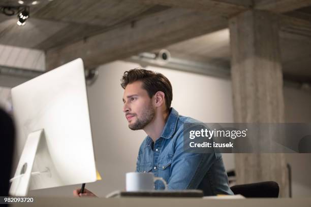 creatieve professional werken aan zijn bureau - fotoredacteur stockfoto's en -beelden