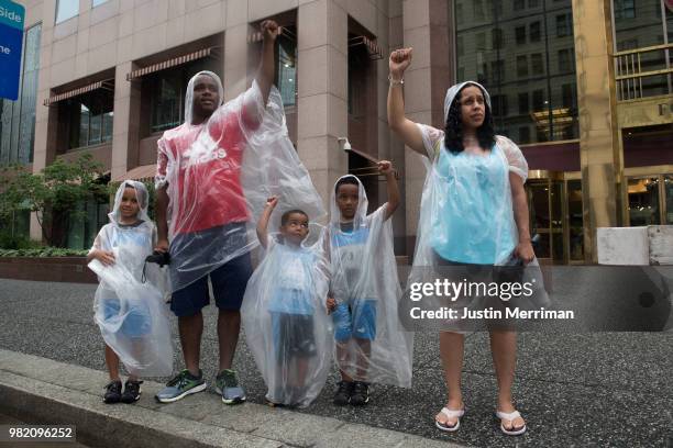 Rev. William Baker, his wife, Denise, and children, left to right, Uriah William and Noah stand and watch a march for the police shooting of Antwon...