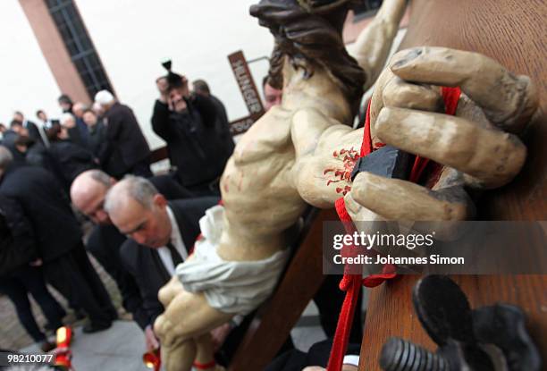 Members of the town's crafts guilds decorate a baroque sculpture Christ hanging on the cross during a Good Friday procession on April 2, 2010 in Lohr...