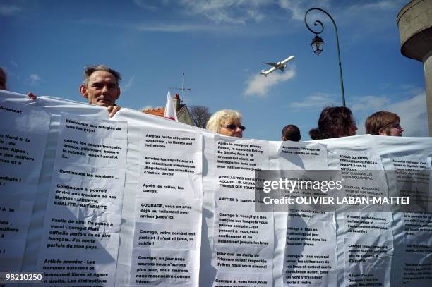 Quelques manifestants déploient un drap blanc avec des messages écrits à destination des retenus du centre de rétention administrative du...