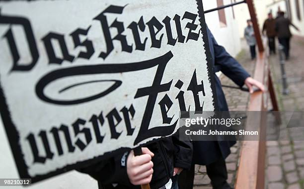 Little boy displays a sign reading 'The Cross Of Our Times' ahead of a Good Friday procession on April 2, 2010 in Lohr am Main, Germany. Several...