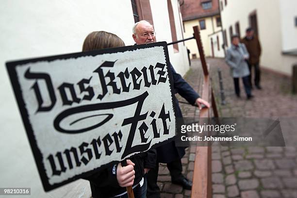Little boy displays a sign reading 'The Cross Of Our Times' ahead of a Good Friday procession on April 2, 2010 in Lohr am Main, Germany. Several...