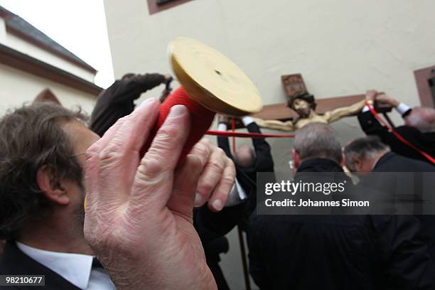 Members of the town's crafts guilds decorate a baroque sculpture Christ hanging on the cross during a Good Friday procession on April 2, 2010 in Lohr...